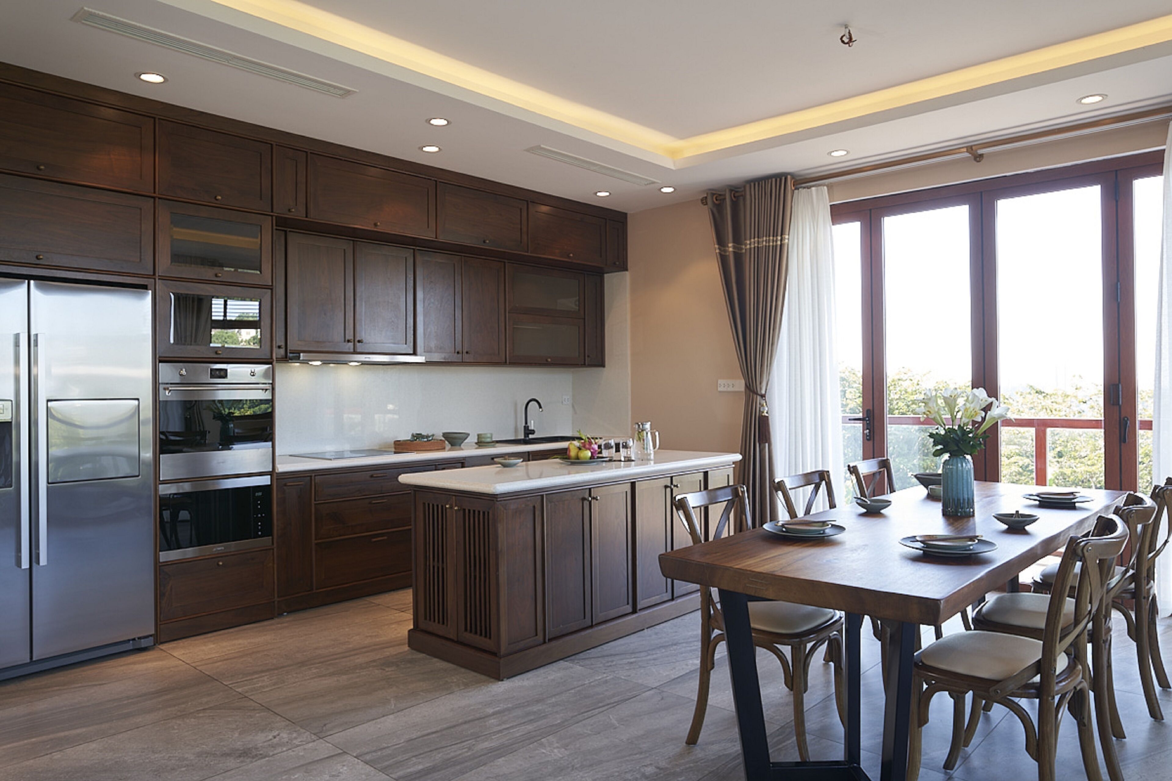 A modern kitchen with dark wood cabinets, stainless steel appliances, and a central island with seating.