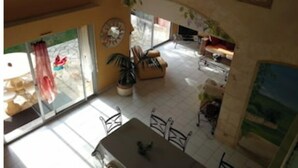 Un grand espace de vie comprenant une table à manger et des chaises, un canapé et un téléviseur.