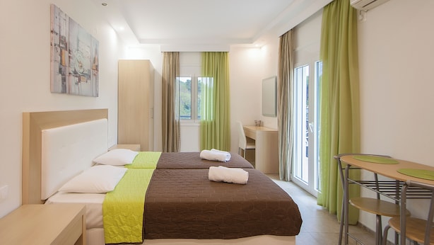 Una habitación de hotel con una cama, un escritorio y una silla.