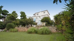 Una casa con muro de piedra y patio cubierto de césped.