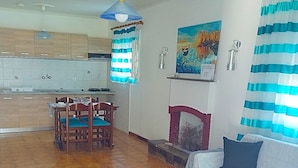 Una sala de estar con una mesa de centro de madera, un sofá y un comedor con sillas.