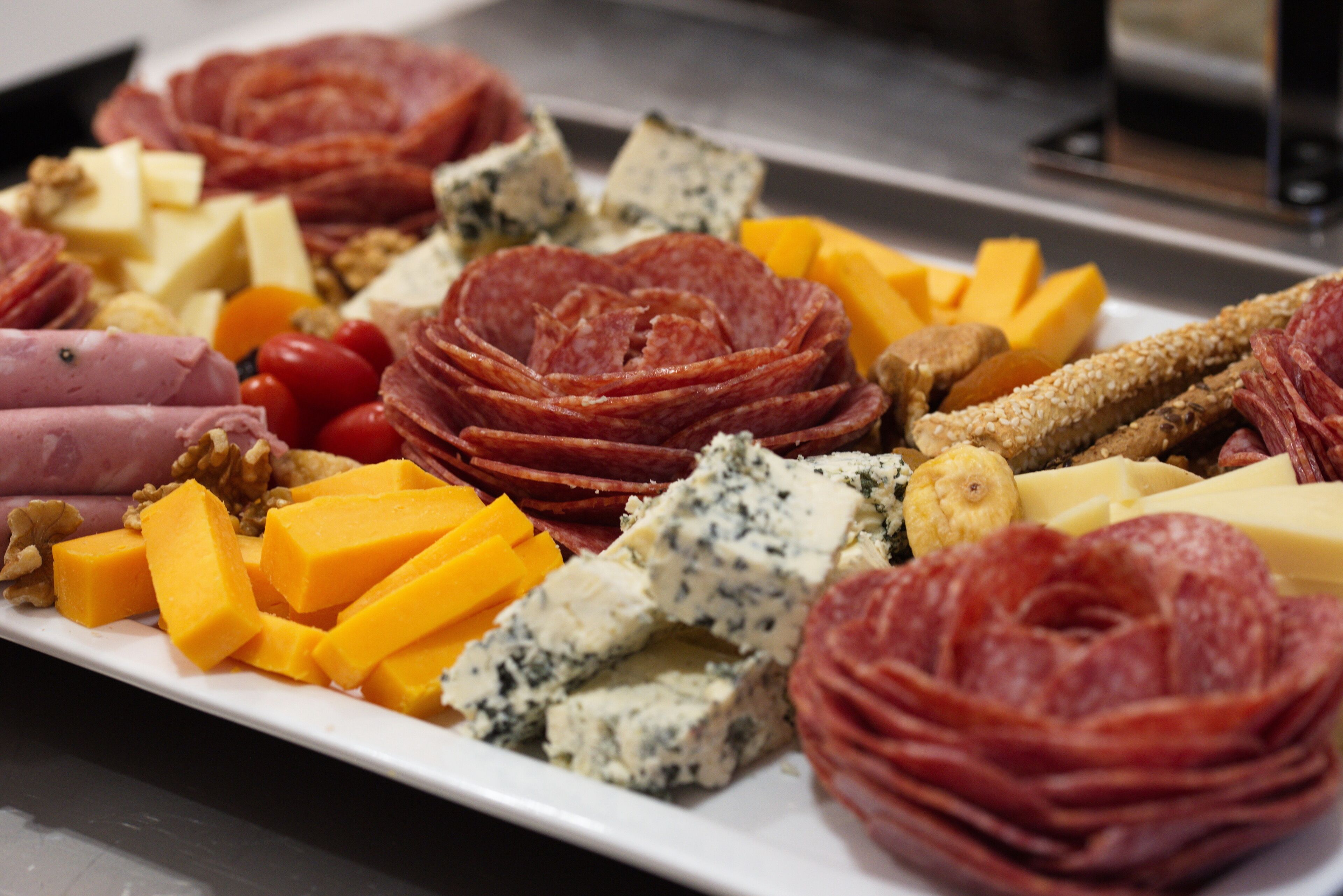 A platter of assorted cheeses, meats, and nuts.