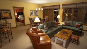 A cozy living room with a sectional sofa, a leather armchair, a wooden coffee table, and plaid-patterned window treatments. - Ski-in Ski-out Luxurious 3 Bed 3 Bth + Free Ski Passes @ Teton Club (Jackson)