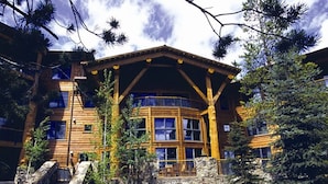 A log cabin-style building with a stone foundation, wooden exterior, and a balcony. - Ski-in Ski-out Luxurious 3 Bed 3 Bth + Free Ski Passes @ Teton Club (Jackson)