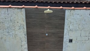 A closed door with a small window, a tiled floor, and a stone bench. - House with Pool in Itanhaém – Family and Pets (Itanhaém)