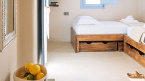 Um quarto com cama de madeira, uma pequena janela, um espelho e uma tigela de limões sobre uma mesa.