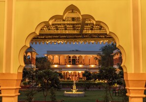 A traditional building with a central courtyard, arched windows, and a fountain. - Shahpura Abhaneri Resort (Baswa)