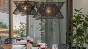 Een eettafel gedekt met borden, glazen en een potplant.