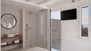 Une salle de bain moderne avec un grand miroir, un lavabo blanc et une douche.