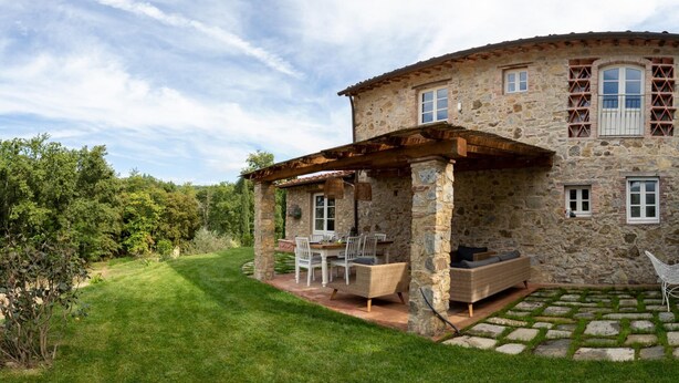 A stone house with a covered patio, outdoor seating, and a well-maintained lawn. - Anticiana 8 (Lucca)
