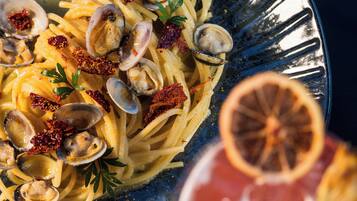 A plate of pasta with clams and lemon garnish.