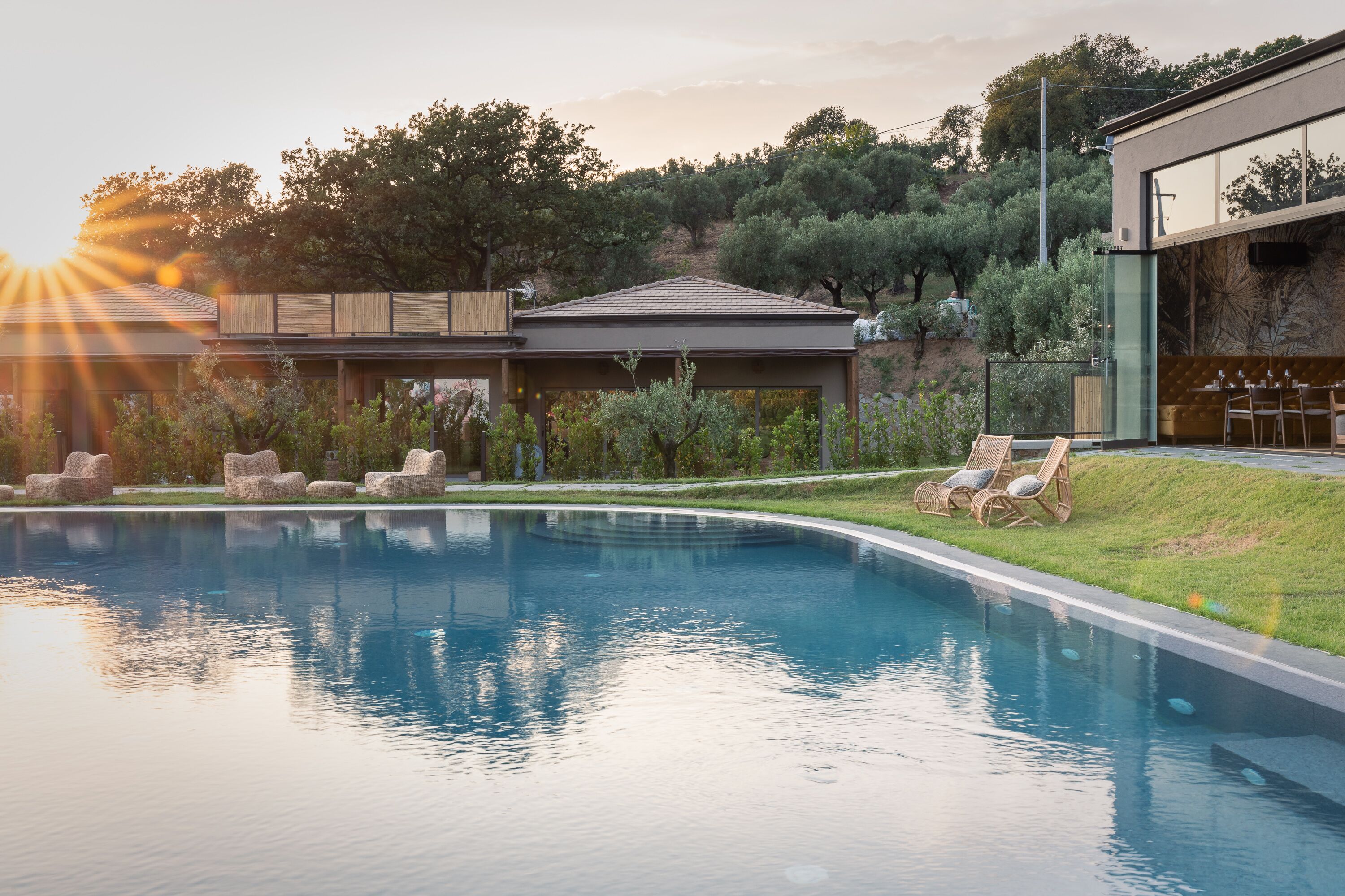 Uma área de piscina moderna com espreguiçadeiras e um deck de madeira.