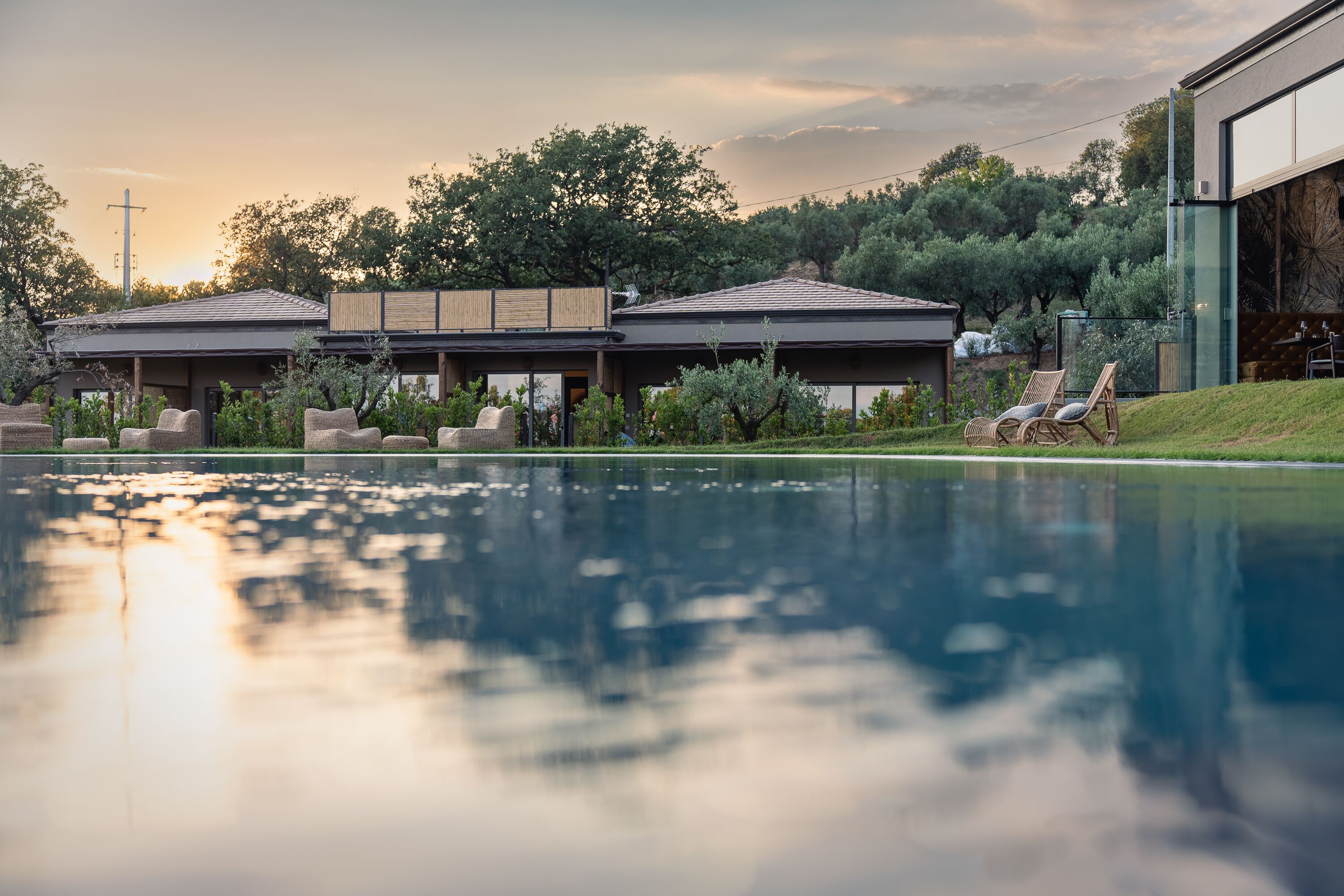 Un espace piscine avec des chaises longues et un patio couvert.