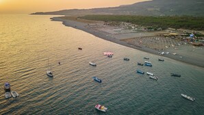A coastal area with boats, a beach, and a town.