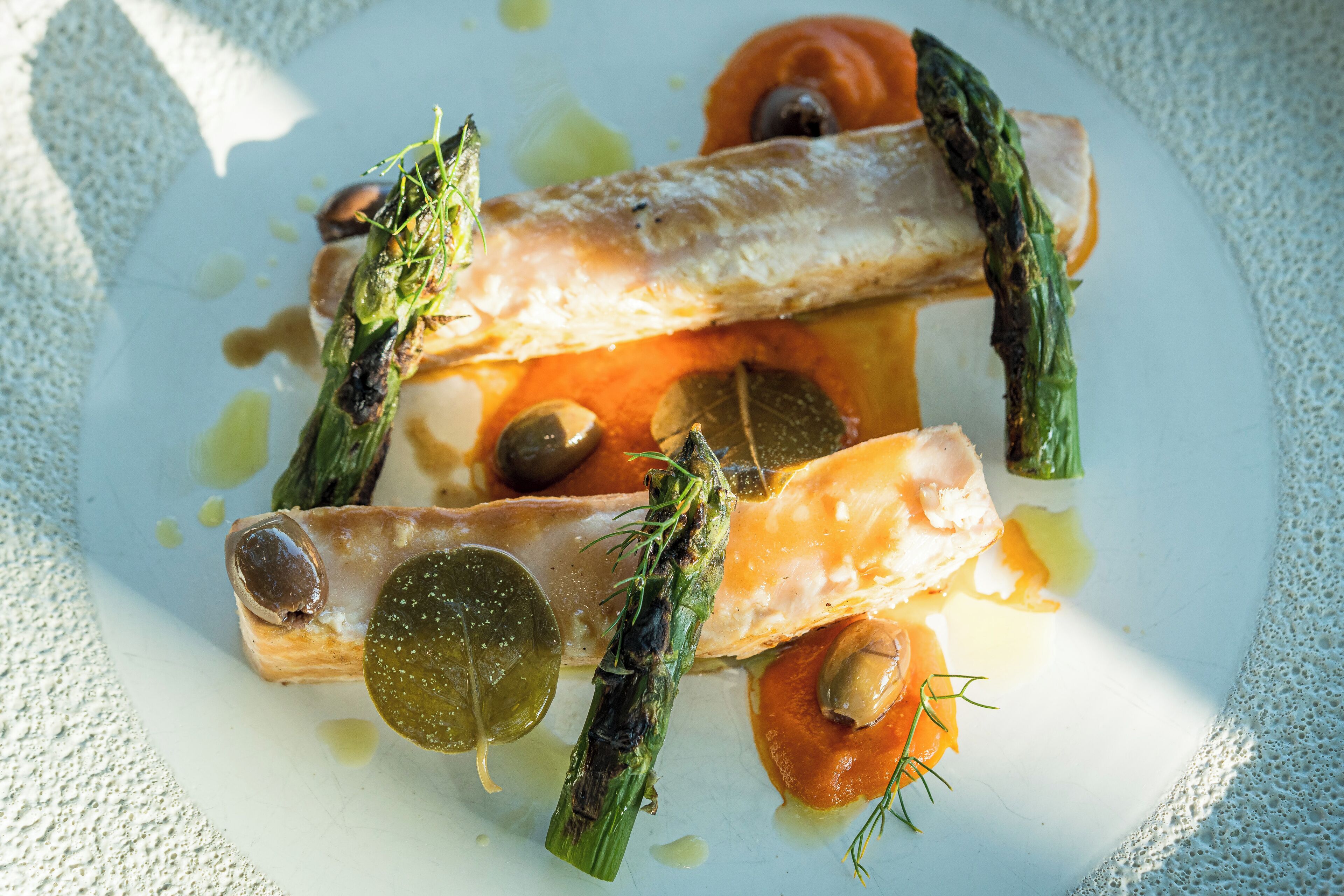 A plate of food with various vegetables and a piece of fish.