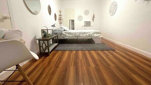 Une chambre à coucher comprenant un lit, une chaise, un bureau, un miroir et des éléments décoratifs sur les murs.