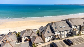 A coastal residential area with houses, a beach, and a clear sky. - Carbis Bay Luxury 3 Bed Penthouse Apartment with Sea Views Parking Sauna Balcony (Carbis Bay)