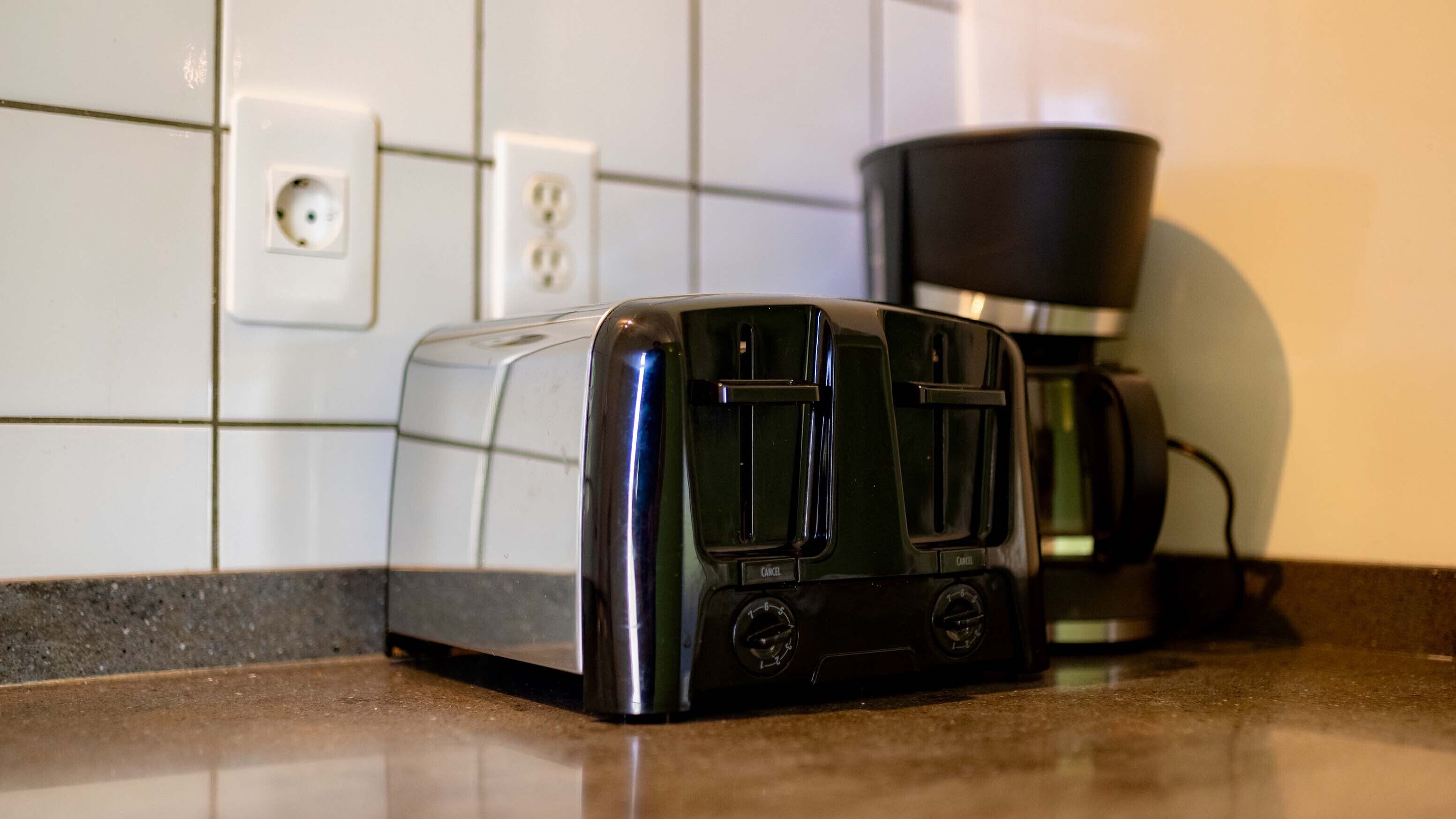 A kitchen with a toaster and a coffee maker on the counter.