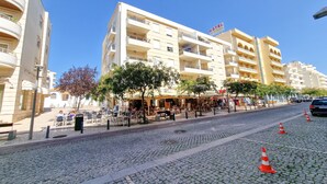 A hotel with multiple floors, outdoor seating, and a cobblestone street.
