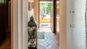 A hallway with a tiled floor, a wooden ceiling, and a clock on the wall. - Podere Vergianoni immersed in Chianti with swimming pool (Noce)