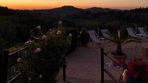 A sunset view from a terrace with lounge chairs and a pathway. - Podere Vergianoni immersed in Chianti with swimming pool (Noce)