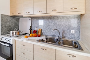 Eine Küche mit Granit-Arbeitsplatten, Edelstahlgeräten und Holzschränken.