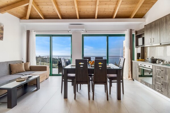 Una cocina moderna con comedor, ventanas amplias y vistas al exterior.