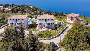 Una propietat a la costa amb diversos edificis, una piscina i vistes al mar.