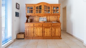 Una cocina con armarios de madera, horno empotrado y ventana con persianas.