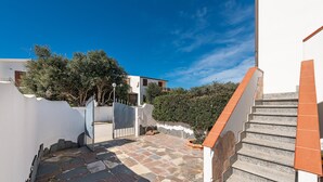 A stone staircase leading to a white building with a red-tiled handrail. - Holiday Home "Sottotorre 2" close to the Sea with Private Garden & A/C (Calasetta)