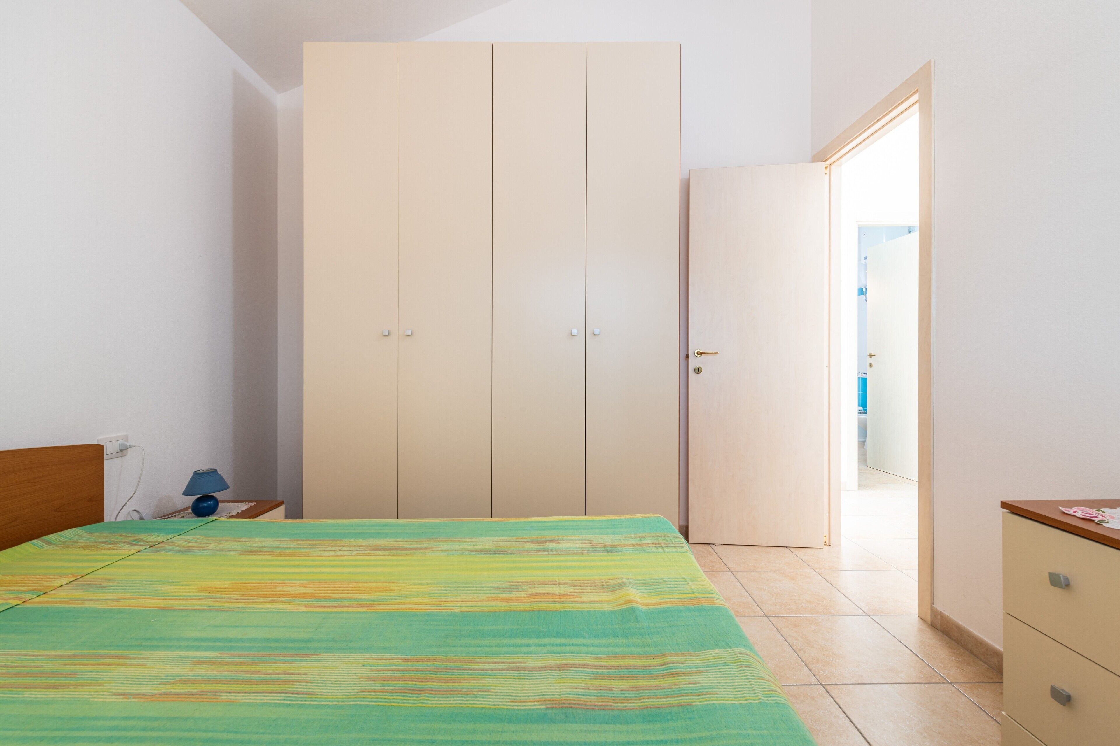Une chambre à coucher comprenant un lit, une armoire, une table de chevet et un bureau.