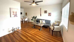 A living room with a ceiling fan, a dining area, and a sofa.