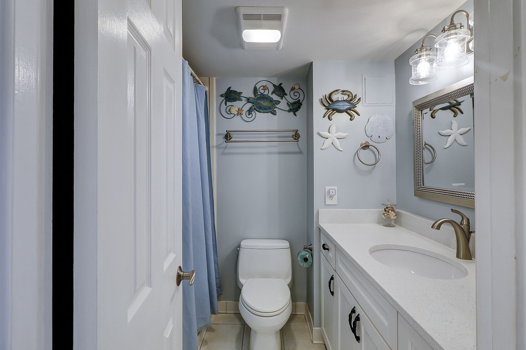 Een badkamer met toilet, wastafel en decoratieve muurkunst.
