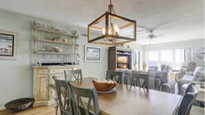 Un comedor con una mesa de madera, sillas y una lámpara colgante.