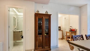 A modern kitchen with wooden cabinets, a dining table, and a kitchen island. - Apartment “Chipiona, Cruz del Mar 1st Line” with Sea Views, Terrace, Parking & Wi-Fi (Chipiona)