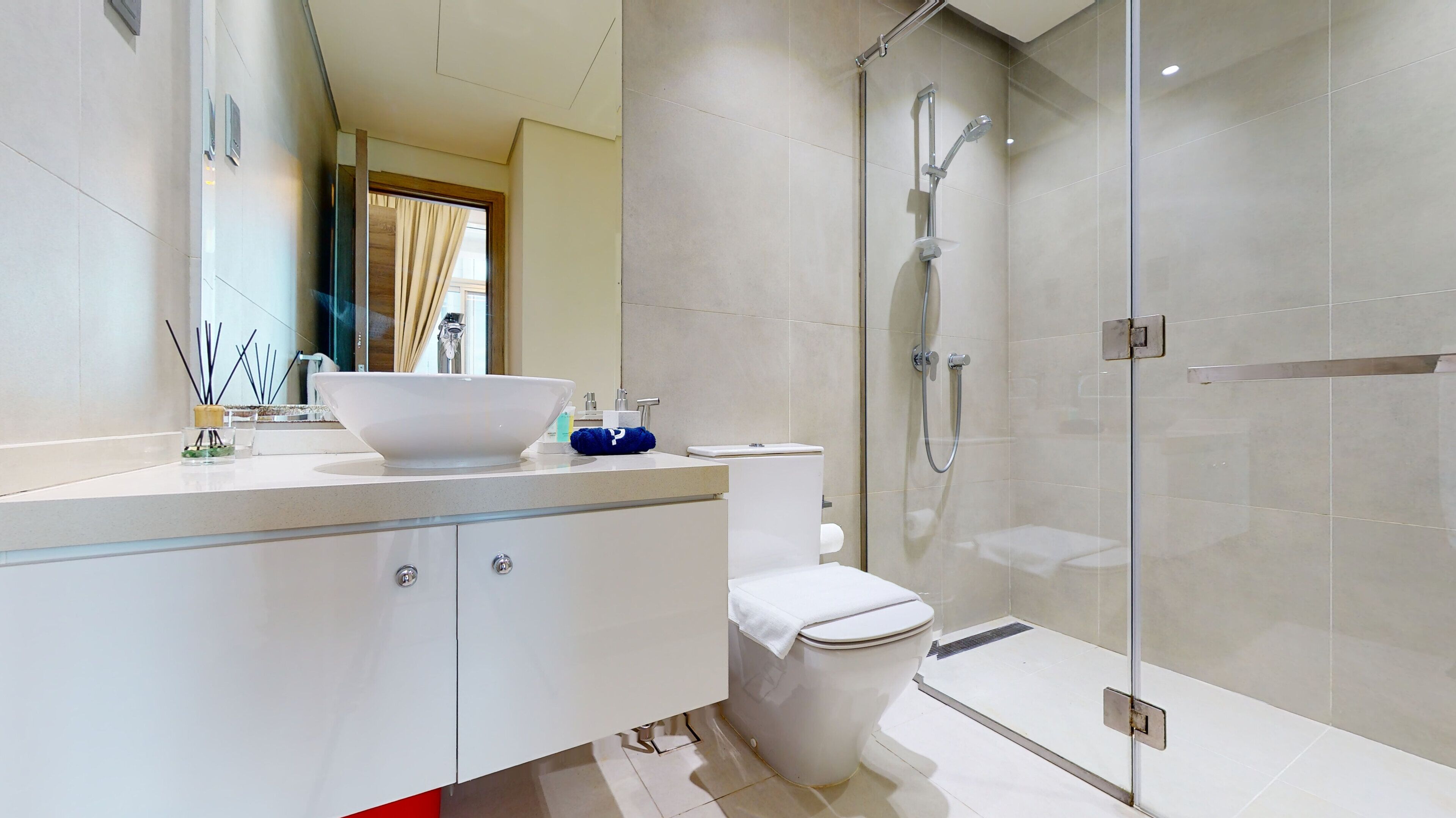Une salle de bain moderne avec une douche à parois de verre, un lavabo blanc et des toilettes.