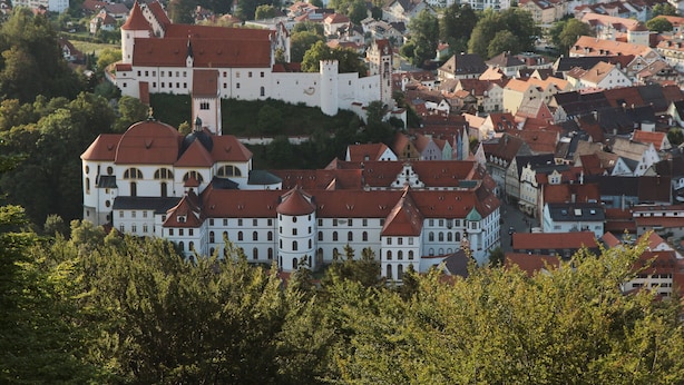 En historisk stad med en framträdande, slottsliknande byggnad som omges av bostadshus.