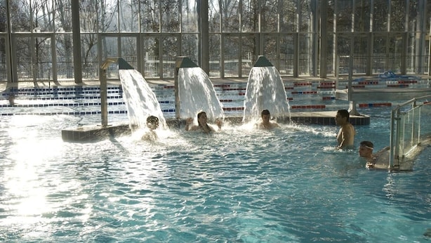 Una piscina con varias pistas y un tobogán de agua.