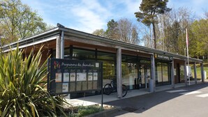 Un edificio moderno con un área de espera techada y un cartel que dice 'Programme des Animations'.