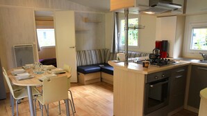 Una cocina compacta con comedor, estufa integrada y un rincón de estar con banco.