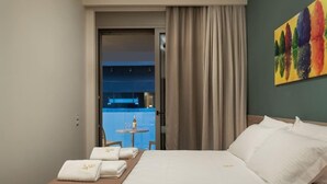 A hotel room with a bed, towels, a painting, and a view of a balcony.