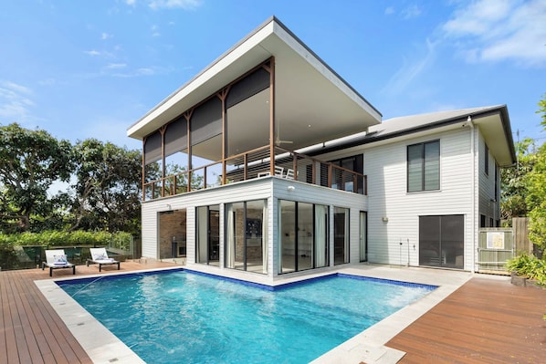 Beautiful pool wrapping around house with balcony overlooking