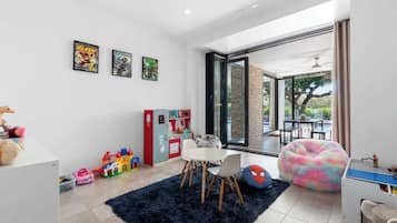 A modern living room with a dining area, a large window, and a view of the outdoors.