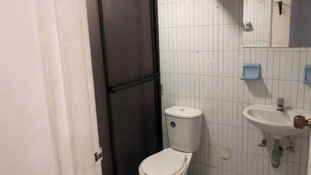 Une petite salle de bain avec des toilettes, un lavabo et un miroir.