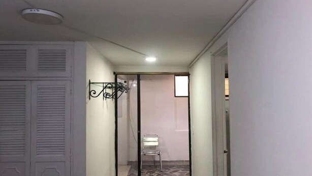 A narrow hallway with a tiled floor, a white door on the left, and a mirrored closet door on the right. - Comfortable, central and well located apartment - Apt 201 (Medellín)