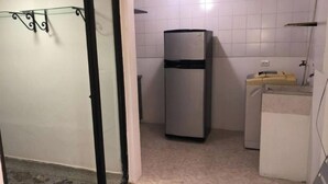 A small kitchen with a refrigerator, a washing machine, and a sink. - Comfortable, central and well located apartment - Apt 201 (Medellín)