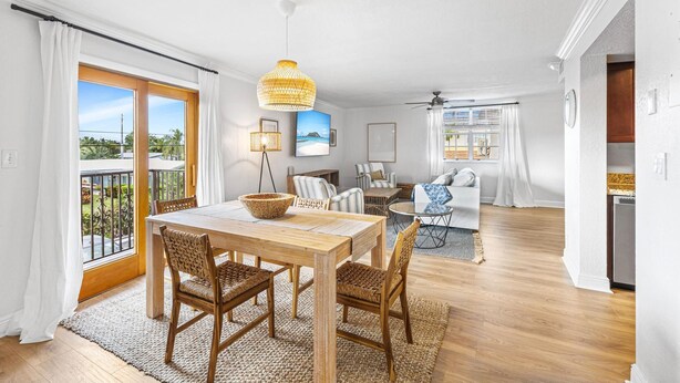 A spacious living area with a wooden dining table, wicker chairs, a sofa, and a ceiling fan. - 3 Queen Beds, 5 min Walk to the Beach - 70 inch Smart TV (Lauderdale-by-the-Sea)