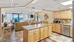 Una cocina amplia con armarios de madera, encimera de granito y vistas al exterior.