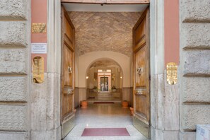 A grand entrance with a marble floor, wooden doors, and a brick ceiling. - Superior GetInRome Vaticano apARTment | 5 min Vatican Museums, 2 min Metro (Roma)