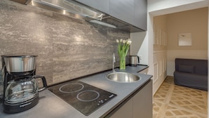 A modern kitchen with a built-in induction cooktop, a coffee maker, and a sink. - Selected & Private apARTment. Double check cleaning mode. Smart customer service (Roma)